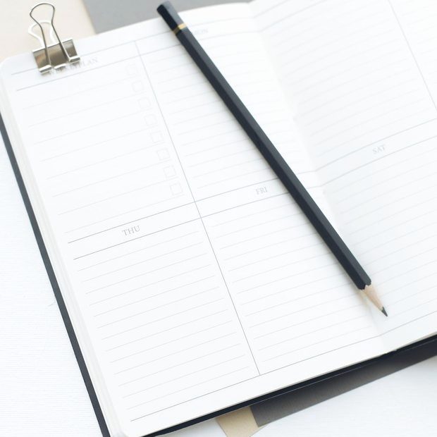 Opengeslagen weekplanner met aankruisvakjes en een potlood erop